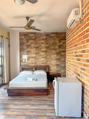 a bedroom with a bed and a brick wall at Hotel Casa Madrid in Puerto Berrío