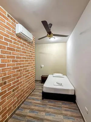 a bedroom with a bed and a brick wall at Hotel Casa Madrid in Puerto Berrío