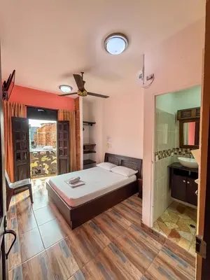 a bedroom with a bed and a bathroom with a sink at Hotel Casa Madrid in Puerto Berrío