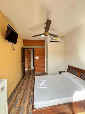 a bedroom with a bed and a flat screen tv at Hotel Casa Madrid in Puerto Berrío