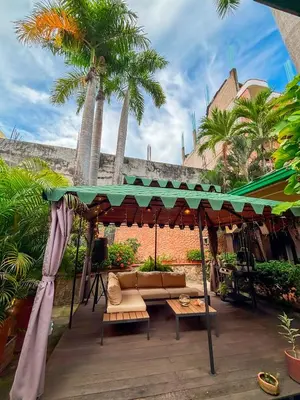 a gazebo with a couch and palm trees at Hotel Casa Madrid in Puerto Berrío