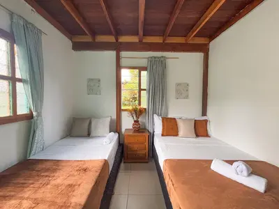 a bedroom with two beds and a window at Las Casas de Tomate in Guatapé