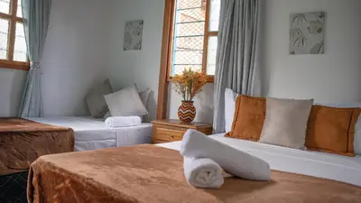 a hotel room with two beds and a window at Las Casas de Tomate in Guatapé