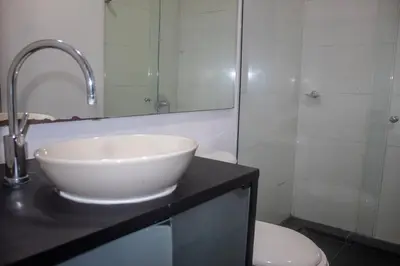a bathroom with a sink and a toilet and a mirror at Apartment near Provence pool, gym, views and WiFi in Medellín