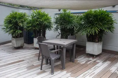 a table and chairs on a patio with plants at Apartment near Provence pool, gym, views and WiFi in Medellín