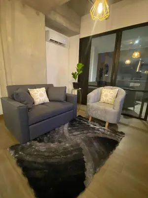 a living room with a blue couch and a chair at El Poblado, Medellin, Antioquia, Colombia in Medellín