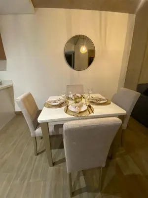 a white table with chairs and a mirror at El Poblado, Medellin, Antioquia, Colombia in Medellín