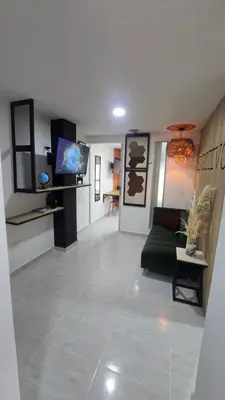 a living room with a green couch and a tv at Sensitivo Home in Envigado