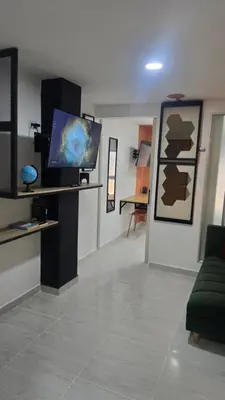 a living room with a couch and a tv on a wall at Sensitivo Home in Envigado
