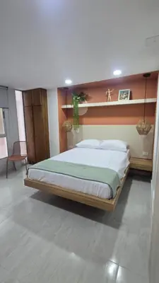 a bedroom with a large bed with a wooden headboard at Sensitivo Home in Envigado