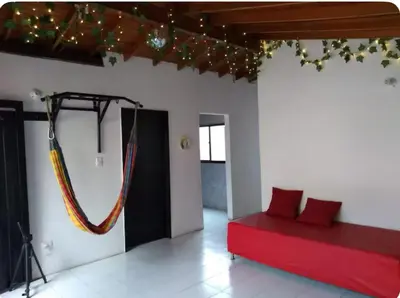 a room with a red bed and a hammock on the wall at Acogedora Habitación Privada - Belén Rosales Laureles in Medellín