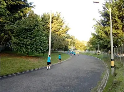two people running down a road in a park at Acogedora Habitación Privada - Belén Rosales Laureles in Medellín