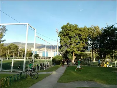 a group of people walking in a field with a park at Acogedora Habitación Privada - Belén Rosales Laureles in Medellín