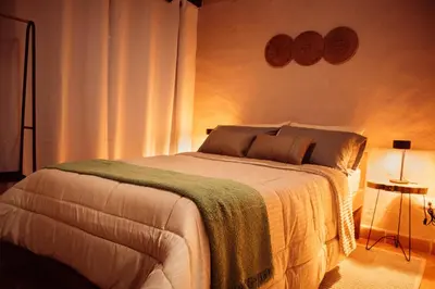 a bedroom with a bed and two lamps on the wall at Casa Samai Embera in Rionegro