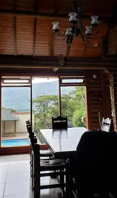 a dining room with a table and chairs and a large window at Cabaña en Copacabana Antioquia, cerca a Medellín in Copacabana