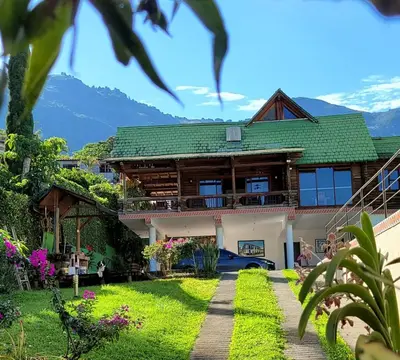 a house with a green roof and a yard at Cabaña en Copacabana Antioquia, cerca a Medellín in Copacabana