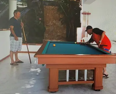 two men playing a game of pool with a table at Cabaña en Copacabana Antioquia, cerca a Medellín in Copacabana