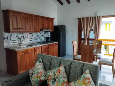 a living room with a couch and a kitchen at Refugio Chamahua in Jericó