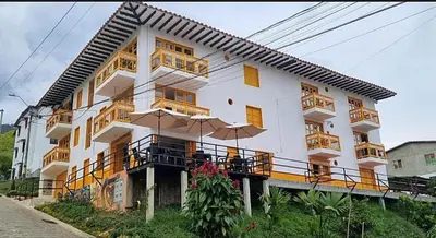 a large white building with tables and umbrellas at Refugio Chamahua in Jericó
