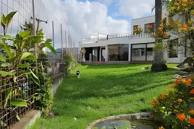 a dog standing in the yard of a house at Casa Campestre, Ubicación Central in Manizales
