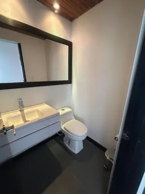 a bathroom with a toilet and a sink and a mirror at Casa Campestre, Ubicación Central in Manizales