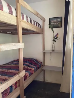 a bedroom with two bunk beds and a table at Hostal Las Hamacas,Habitación #5 in Villamaría
