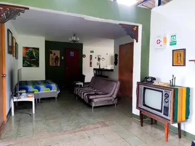 a living room with a tv and a couch at Hostal Las Hamacas,Habitación #5 in Villamaría