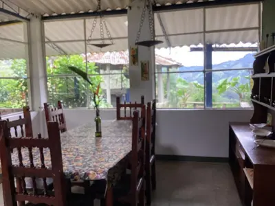 a dining room with a table and chairs and windows at Hostal Las Hamacas,Habitación #5 in Villamaría