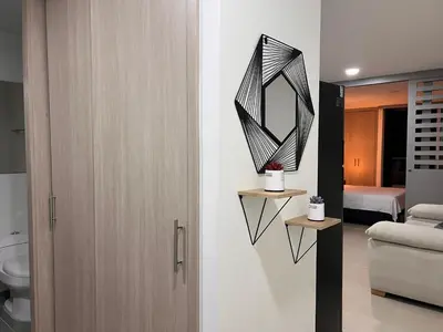 a bathroom with a toilet and a mirror on the wall at Apartasuite Sabaneta Vista a la ciudad parking in Sabaneta