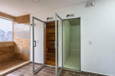 a bathroom with a shower and a glass door at Apartasuite Sabaneta Vista a la ciudad parking in Sabaneta