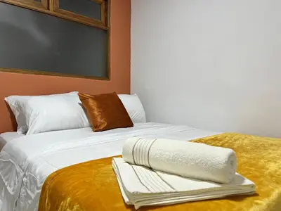 a bed with white sheets and a towel on it at Apartamento Carmelina-solo a dos cuadras del parque in Carmen de Viboral