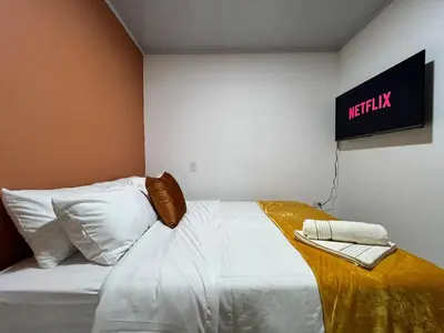 a bedroom with a white bed with a sign on the wall at Apartamento Carmelina-solo a dos cuadras del parque in Carmen de Viboral