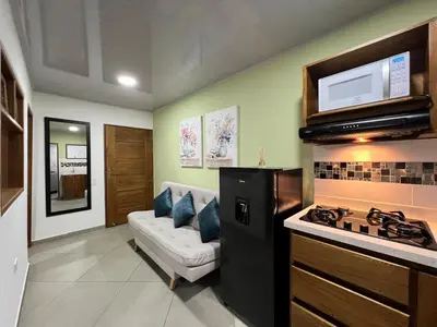a living room with a stove and a couch at Apartamento Carmelina-solo a dos cuadras del parque in Carmen de Viboral