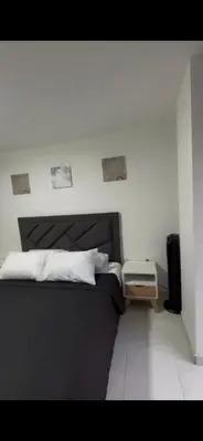 a bedroom with a bed with a black head board at CÓMODO APARTAMENTO CERCA De TODO EN ENVIGADO in Envigado