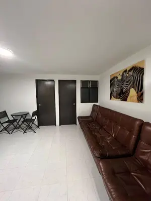 a living room with a brown leather couch and a table at CÓMODO APARTAMENTO CERCA De TODO EN ENVIGADO in Envigado