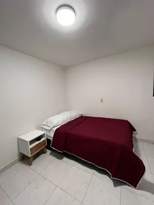 a white bedroom with a bed and a night stand at CÓMODO APARTAMENTO CERCA De TODO EN ENVIGADO in Envigado