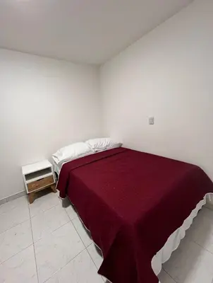 a bedroom with a bed with a red blanket at CÓMODO APARTAMENTO CERCA De TODO EN ENVIGADO in Envigado