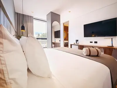 a bedroom with a large white bed with pillows at Moa Select in Medellín