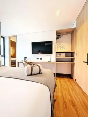 a bedroom with a bed with a tv on the wall at Moa Select in Medellín