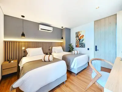 a bedroom with two beds and a tv at Moa Select in Medellín