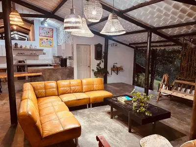 a living room with a leather couch and a table at Cozy villa near El Poblado in Envigado