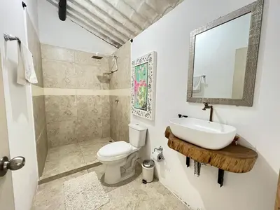 a bathroom with a sink and a toilet and a mirror at Cozy villa near El Poblado in Envigado
