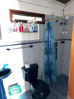 a bathroom with a black toilet and a shower at Finca La Tabaiba in Fredonia