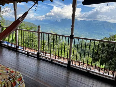 a hammock on a porch with a view of the mountains at Finca La Tabaiba in Fredonia