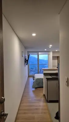 a room with a kitchen and a large window at Mirador del Ruiz Aparta Estudio in Manizales