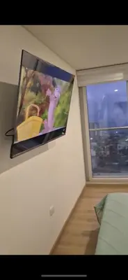 a flat screen tv hanging on a wall next to a window at Mirador del Ruiz Aparta Estudio in Manizales