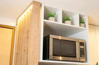 a microwave on a shelf with plants in it at Staynova loft acogedor en El Poblado, Medellín in Medellín