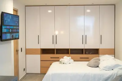 a bedroom with white cabinets and a bed at Staynova loft acogedor en El Poblado, Medellín in Medellín