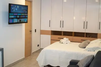 a bedroom with a bed with a tv on the wall at Staynova loft acogedor en El Poblado, Medellín in Medellín