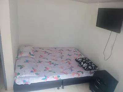 a small bed in a room with a tv at La fonda in Santa Rosa de Cabal